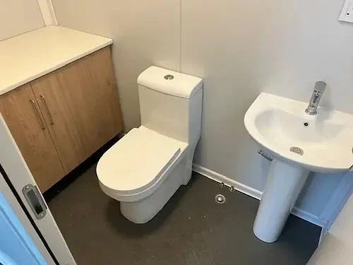 Contenedor equipado en oficina con baño y espacio de almacenamiento